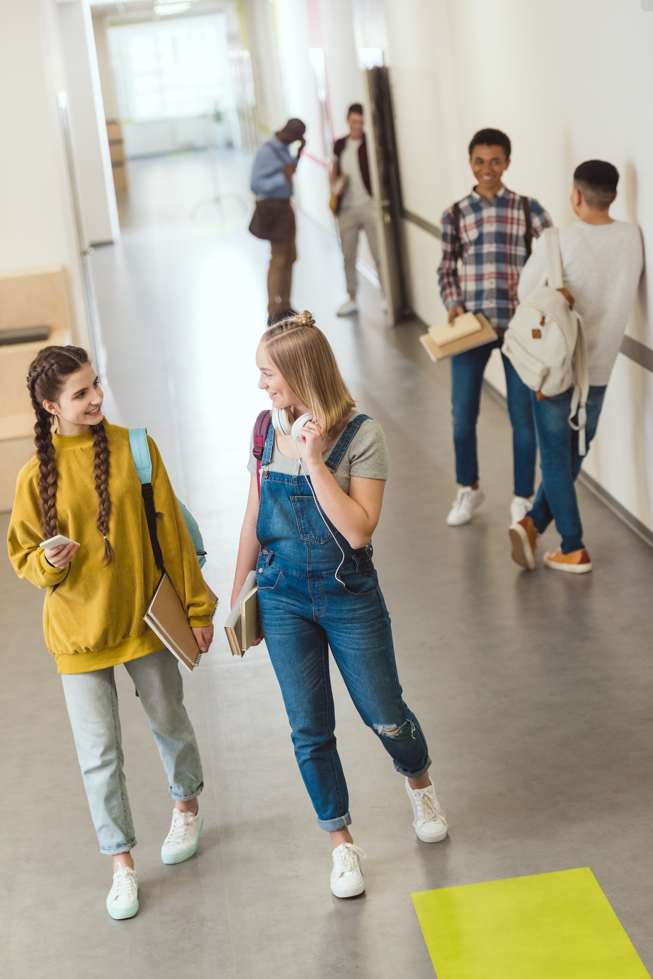 group of multiethnic high school students spending time at school corridor during break